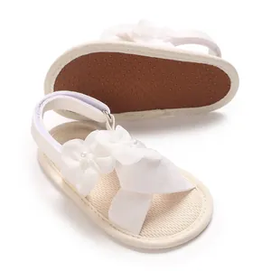 Détail de sandales blanches pour bébés filles avec fleurs et semelle antidérapante
