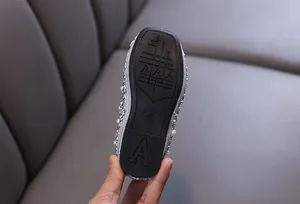 Close-up of anti-slip rubber sole on sparkling rhinestone princess shoes for girls