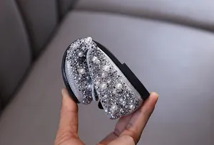 Detailed macro view of girls' princess dress shoes with silver rhinestones and pearls.