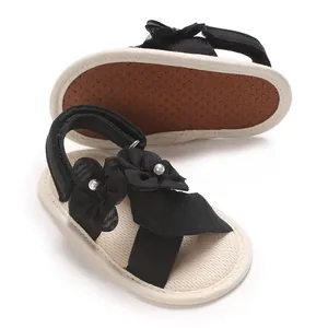 Détail de sandales noires pour bébés filles avec perles florales et semelles souples