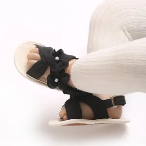 Gros plan de sandales noires pour bébé fille avec fleurs et semelles souples pour tout-petits