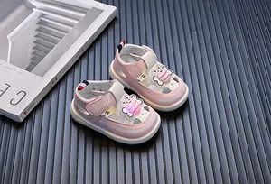 Detail van roze babysandalen met een oplichtend LED-ornament van een cartoonbij