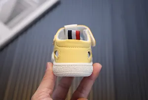 Gedetailleerd overzicht van de hiel van een gele baby sandaal met gestreepte band