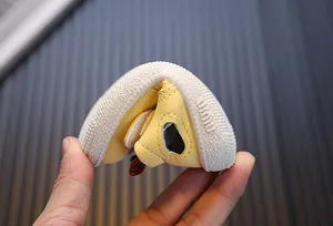 Detailopname van de hoge flexibiliteit en zachte zool van de gele babyloopschoen.
