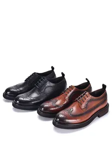 Close-up of black and brown leather brogue shoes with carved detailing and thick soles.