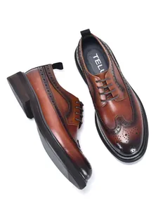 Detail view of brown leather brogue shoes with classic wingtip carving and thick sole