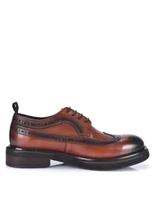 Side view detail of brown leather brogue shoes featuring carved patterns and thick soles