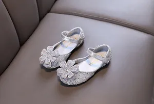 Close-up of silver girls princess shoes with large rhinestone flower detail.