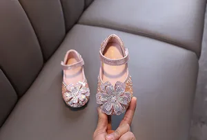 Detailed view of pink rhinestone princess shoes for girls with a large flower accent