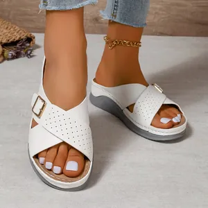 Elegant white wedge sandals with crossover straps and gold buckle detail