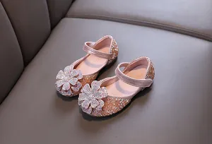 Detail of pink girl's princess shoes featuring sparkling crystal flower decorations.