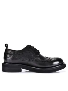 Side view detail of black leather men's brogue shoes with thick soles and wingtip design