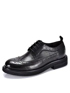 Side view of men's black leather brogue shoes with platform sole and wingtip detail