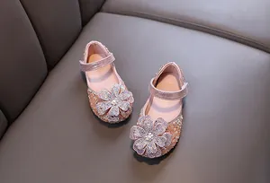 Close-up of sparkly pink girl's princess shoes featuring a large rhinestone flower