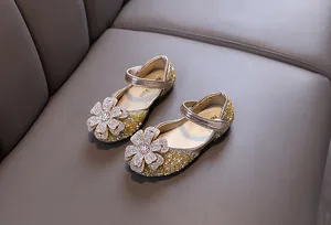 Detail view of golden rhinestone princess shoes for girls with sparkling floral ornaments.