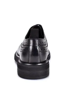 Rear view detail of black leather Brogue shoes showing thick sole and carved patterns