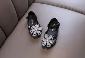 Detailed view of girls' black princess flats with sparkling rhinestone flower