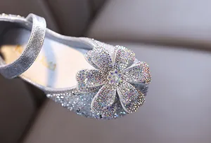 Macro detail of the sparkling rhinestone flower on a girl's silver princess shoe
