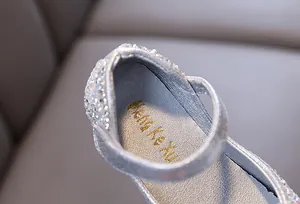 Close-up of sparkling silver rhinestone princess shoes for girls showing glittery details