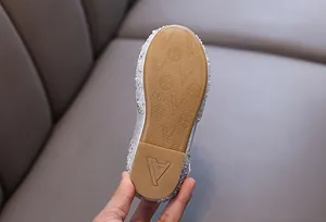 Detailed view of the anti-slip brown rubber sole of girls princess rhinestone dance shoes