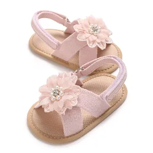 Detail showing the intricate floral lace and pearl decoration on baby girl sandals