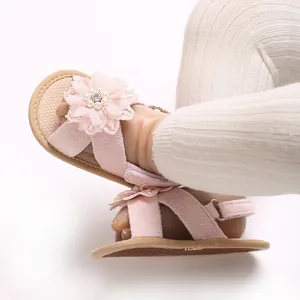 Detail view of pink lace flower and pearl decoration on baby girl princess sandals