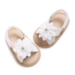 Detailed view of white infant princess sandals with delicate lace flower and pearl accents