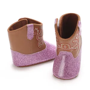 Gedetailleerd overzicht van roze glitter babyloopschoentjes met borduursel in cowboy