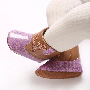 Detailopname van paarse glitter baby meisjes winterlaarzen met bruin zacht leer