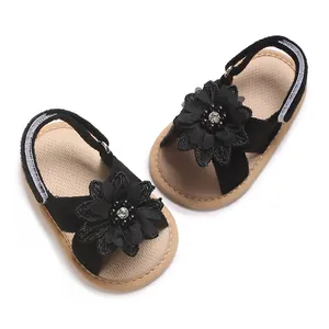 Elegant black baby girl sandals featuring a large fabric flower and soft non-slip sole