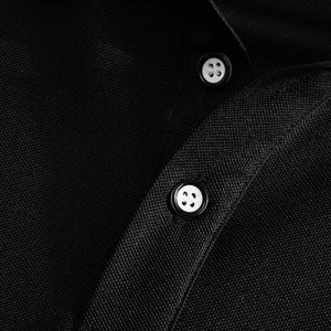 Détail macro du tissu en maille noire et des boutons d'un polo respirant pour homme.
