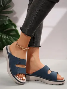 Detailed side view of women's blue platform slides with double straps and studded details