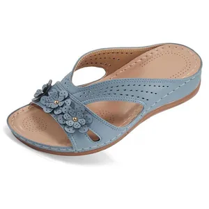 Close-up of blue wedge sandal featuring decorative flowers and laser-cut hollow details