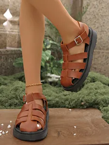 Detailaufnahme brauner geflochtener Römersandalen mit Plateausohle und geschlossener Kappe