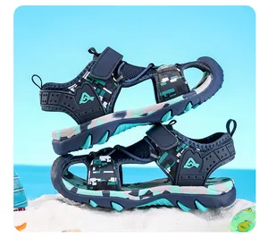 Detailed side view of boys' camouflage closed-toe sandals on a sandy beach background