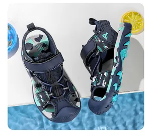 Detail view of boys' closed-toe sandals with navy camo pattern and secure velcro strap.