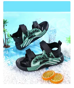 Vue latérale de sandales de sport vertes et noires pour enfants sur galets décoratifs blancs
