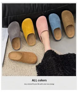 Close-up of colorful suede closed-toe slippers in multiple shades on a textured mat