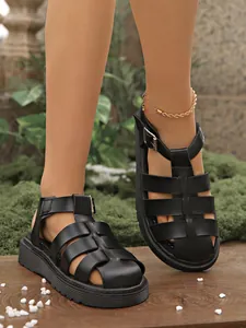 Nahaufnahme von stilvollen schwarzen Vintage-Römersandalen mit dicken Plateausohlen