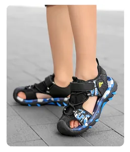 Boys' closed-toe sports sandals with blue camouflage pattern shown on outdoor tile