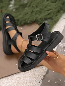 Detailansicht schwarzer geflochtener Damen-Römersandalen mit dicker Retro-Plateausohle