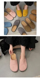 Variety of suede-like closed-toe slippers in soft pastel colors displayed on floor