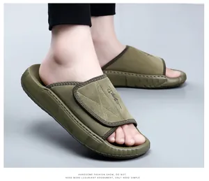 Gros plan de pantoufles en cuir vert olive pour hommes avec semelles épaisses.