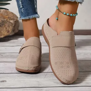 Detail of beige closed-toe mules with decorative laser-cut honeycomb and floral patterns