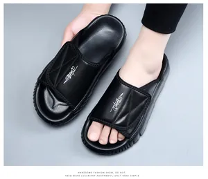 Premium black cowhide leather men's slippers with thick EVA sole and logo detail