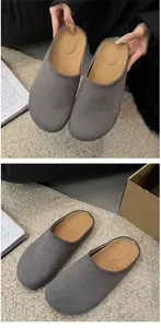 Detail view of women's stylish grey suede-like closed-toe mules on a natural woven rug