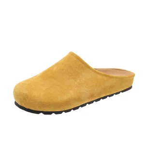 Yellow suede closed-toe mule slippers for women with platform sole and slip-on design.