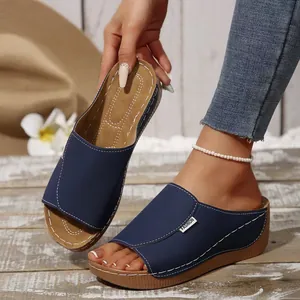 Detail of navy blue wedge sandals with white stitching and comfortable thick sole