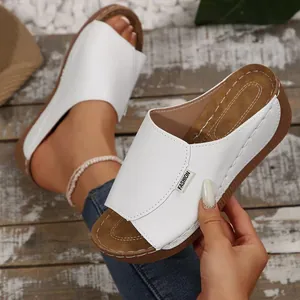 Detail view of comfortable white wedge sandals with open-toe design and faux leather finish