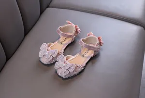 Détail de papillon en strass rose et nœud sur chaussures de princesse brillantes